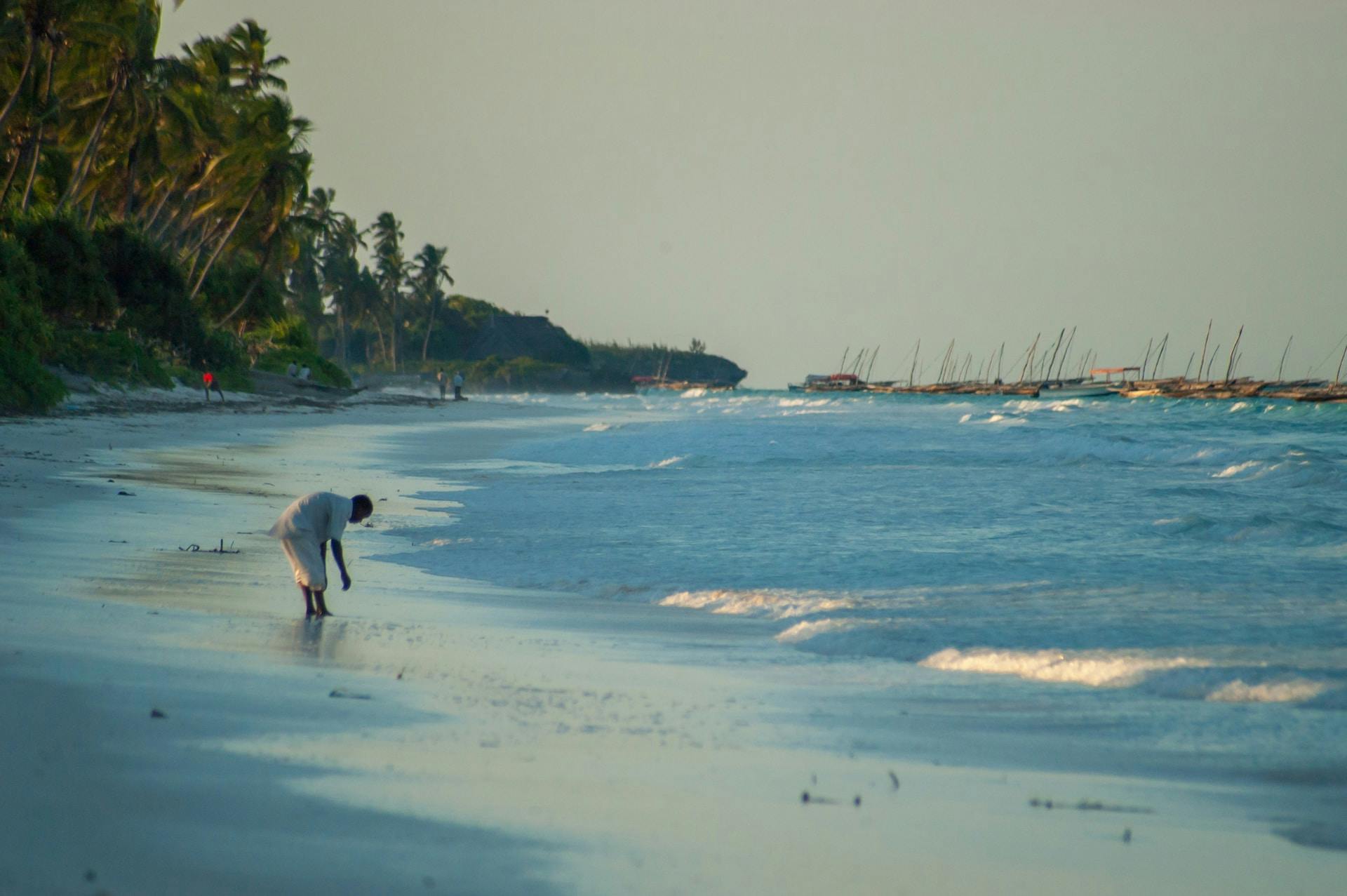 matemwe beach csodás fehér homokos óceánpart hajoló férfi hullámok